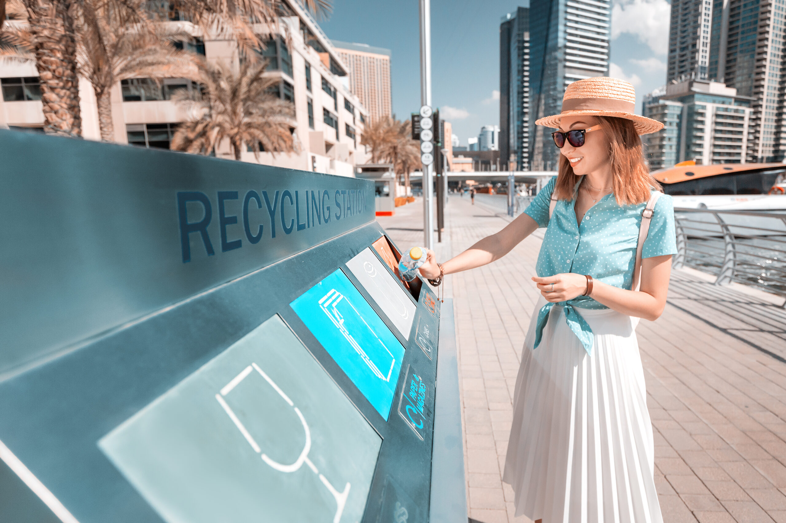  Dubai Can Recycling Initiative. girl sorts and throws garbage in a street station for recycling plastic waste. Environment conservation concept